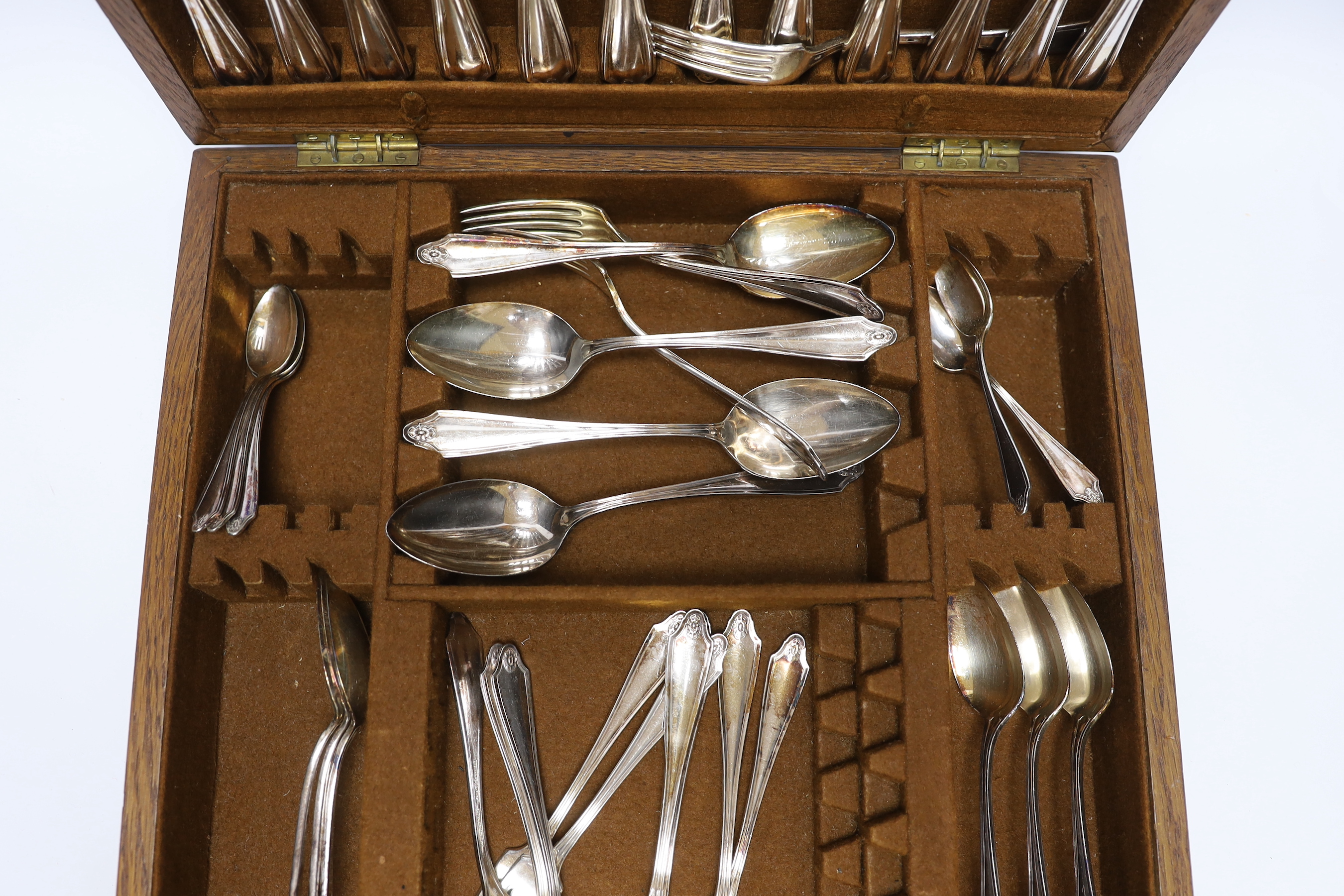An oak cased canteen containing Sheffield ‘Super stainless’ flatware and a pair of plated candelabra, 46cm